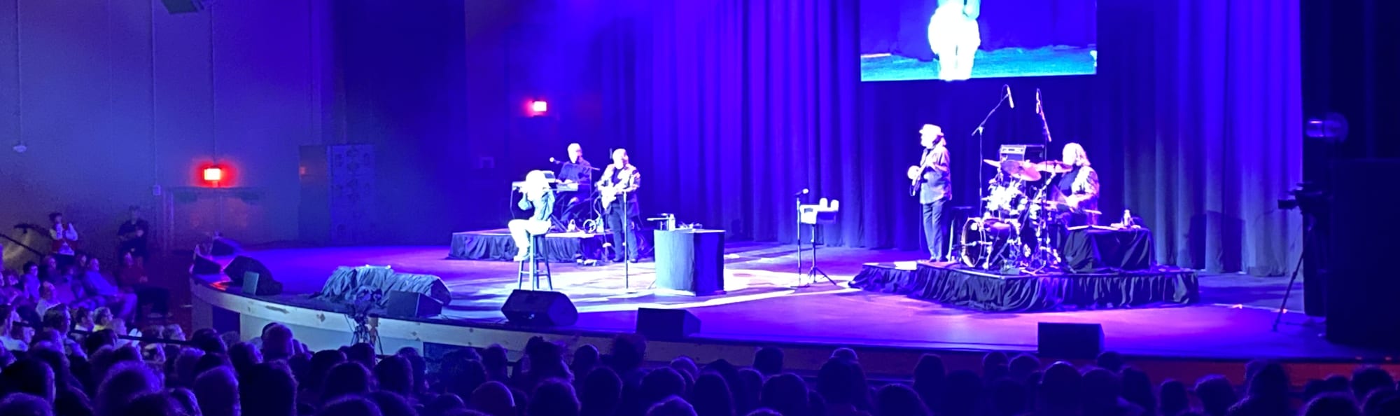 signer on stage in chair washed out by the lights Bakersfield